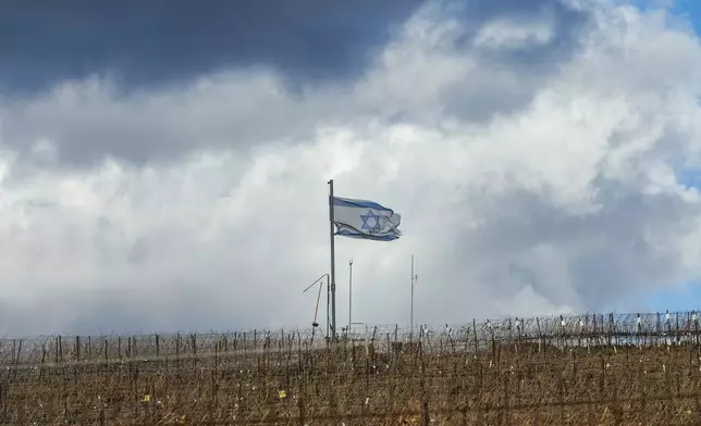 An Israeli flag waves on the top of a hill near the so-called Alpha Line that separates the Israeli-controlled Golan Heights from Syria, in the town of Majdal Shams, Friday, Dec. 13, 2024. (AP Photo/Matias Delacroix)