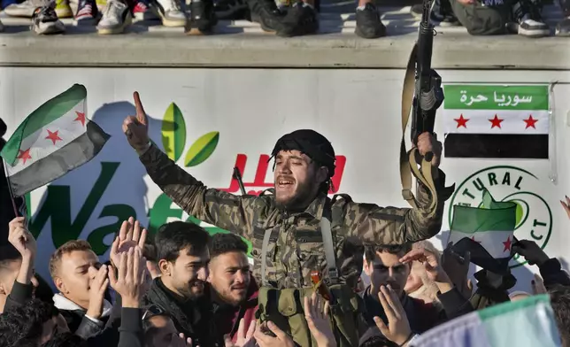 A Syrian member of the rebel group celebrates during a demonstration following the first Friday prayers since Bashar Assad's ouster, in Damascus' central square, Syria, on Friday, Dec. 13, 2024. (AP Photo/Hussein Malla)