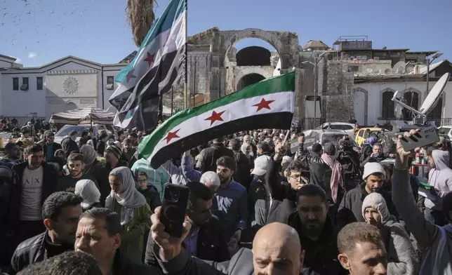 Syrians walk toward he Umayyad mosque for Friday prayers in Damascus, Syria, Friday, Dec. 13, 2024. (AP Photo/Leo Correa)