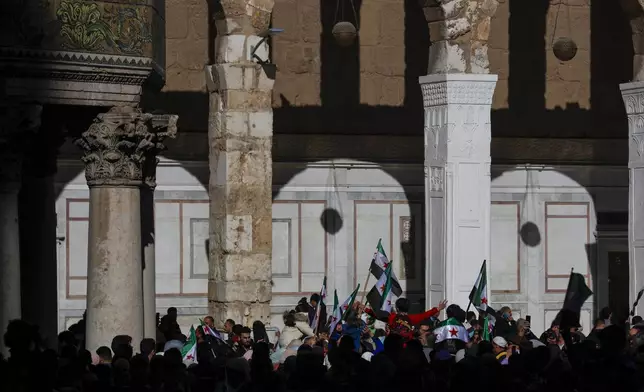 Syrians attend Friday prayers outside the 7th century Umayyad Mosque in Damascus, Syria, Friday, Dec. 13, 2024. (AP Photo/Omar Sanadiki)