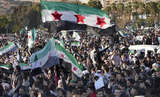 Syrians celebrate during a demonstration following the first Friday prayers since Bashar Assad's ouster, in Damascus' central square, Syria, on Friday, Dec. 13, 2024. (AP Photo/Hussein Malla)