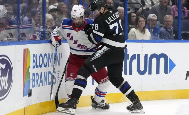 Tampa Bay Lightning defenseman Emil Lilleberg (78) checks New York Rangers left wing Chris Kreider (20) into the boards as they vie for the puck during the first period of an NHL hockey game Saturday, Dec. 28, 2024, in Tampa, Fla. (AP Photo/Chris O'Meara)