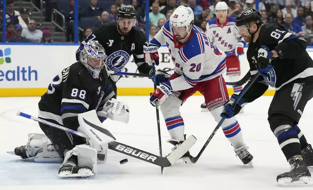 Tampa Bay Lightning goaltender Andrei Vasilevskiy (88) stops a shot by New York Rangers left wing Chris Kreider (20) during the third period of an NHL hockey game Saturday, Dec. 28, 2024, in Tampa, Fla. Defending on the play are Tampa Bay's Ryan McDonagh (27) and Erik Cernak (81). (AP Photo/Chris O'Meara)