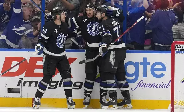 Tampa Bay Lightning defenseman Ryan McDonagh (27) celebrates after his goal against the New York Rangers with left wing Brandon Hagel (38) and center Anthony Cirelli (71) during the first period of an NHL hockey game Saturday, Dec. 28, 2024, in Tampa, Fla. (AP Photo/Chris O'Meara)