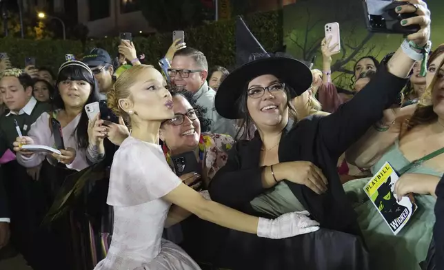 FILE - Ariana Grande, left, poses for a selfie with a fan at the premiere of 'Wicked' at Dorothy Chandler Pavilion in Los Angele, Nov. 9, 2024. (Photo by Jordan Strauss/Invision/AP File)