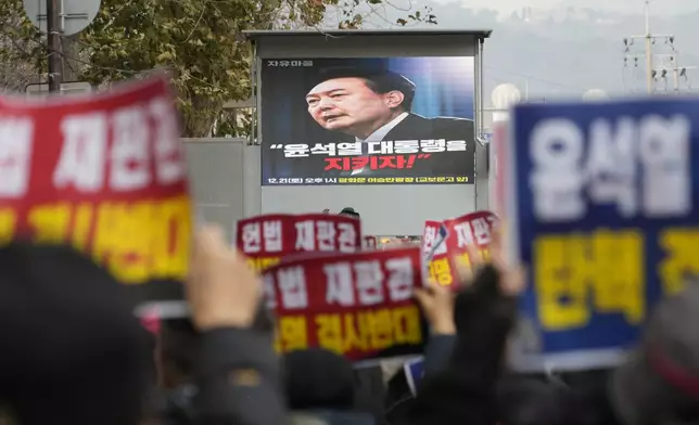 Supporters for impeached South Korean President Yoon Suk Yeol stage a rally against his impeachment near the Constitutional Court in Seoul, South Korea, Friday, Dec. 20, 2024. A screen reads "Let's protect President Yoon Suk Yeol!" (AP Photo/Ahn Young-joon)