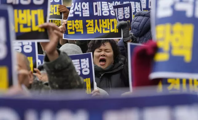 A supporter for impeached South Korean President Yoon Suk Yeol shouts slogans during a rally against his impeachment near the Constitutional Court in Seoul, South Korea, Friday, Dec. 20, 2024. The signs read "Oppose the impeachment of President Yoon Suk Yeol." (AP Photo/Ahn Young-joon)