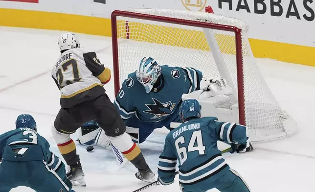 San Jose Sharks goaltender Alexandar Georgiev (40) blocks a shot by Vegas Golden Knights defenseman Shea Theodore (27) during the second period of an NHL hockey game, Friday, Dec. 27, 2024, in San Jose, Calif. (AP Photo/Godofredo A. Vásquez)