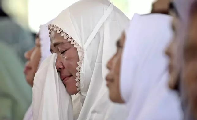 A woman weeps during a prayer marking 20 years of the massive Indian Ocean tsunami, in Banda Aceh, Indonesia, Thursday, Dec. 26, 2024. (AP Photo/Reza Saifullah)