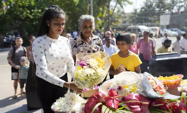 Relatives of tsunami victims offer floral tributes at a memorial built in memory of those who died during 2004 Indian Ocean tsunami as they mark the 20th anniversary in Peraliya, Sri Lanka, Thursday, Dec. 26, 2024. (AP Photo/Eranga Jayawardena)