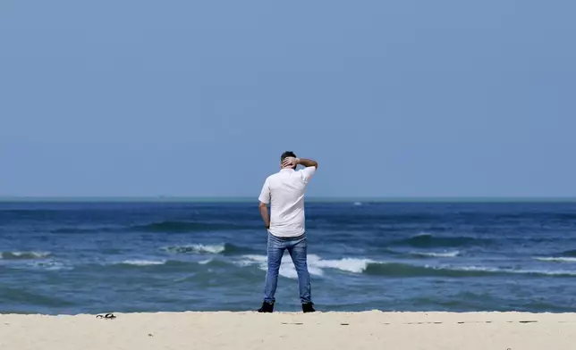 A relative of victim of a 2004 Indian Ocean tsunami stands at Ban Nam Khem beach, Takuapa district of Phang Nga province, southern Thailand, Thursday, Dec. 26, 2024. (AP Photo/Wason Wanichakorn)