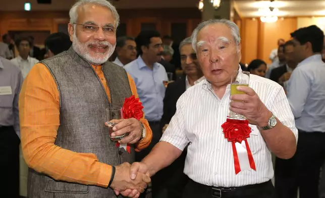 FILE - Then India's Gujarat State Chief Minister Nerendra Modi, left, poses with Suzuki Motor Corp. Chairman and Chief Executive Osamu Suzuki for a photo during a reception of the "Invest Gujarat" seminar in Hamamatsu, southwest of Tokyo, July 25, 2012. (AP Photo/Shizuo Kambayashi, File)