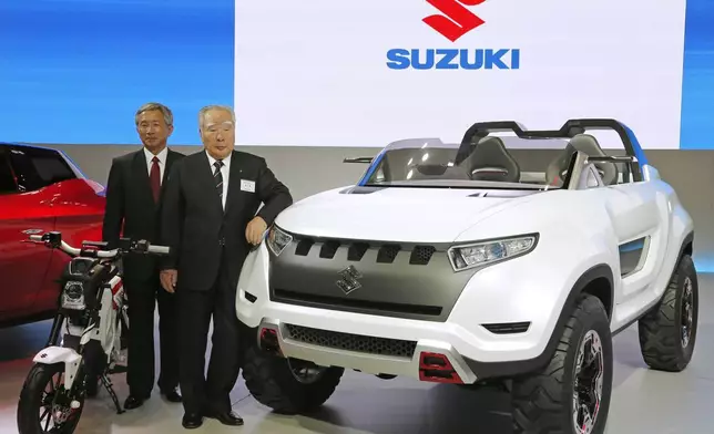 FILE - Suzuki Motor Corp. President and Chairman Osama Suzuki, right, and Vice President Osamu Honda pose with a Suzuki X-Lander hybrid concept car on display at a media preview for the Tokyo Motor Show in Tokyo, Nov. 20, 2013. (AP Photo/Shuji Kajiyama, File)