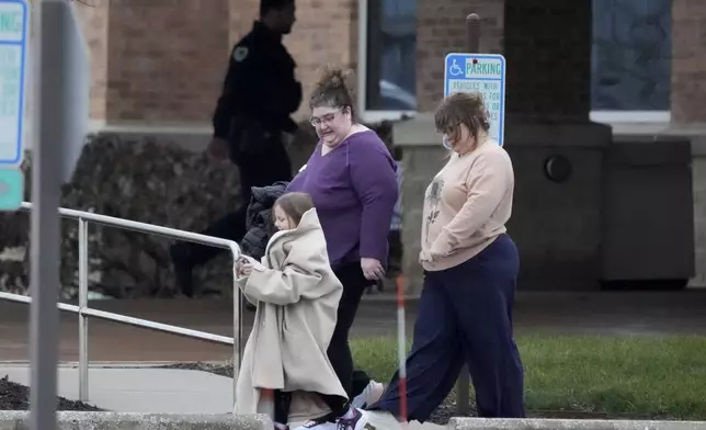 A family leaves the SSMI Health Center, set up as an reunification center, in Madison, Wis., following a shooting, Monday, Dec. 16, 2024. (AP Photo/Morry Gash)