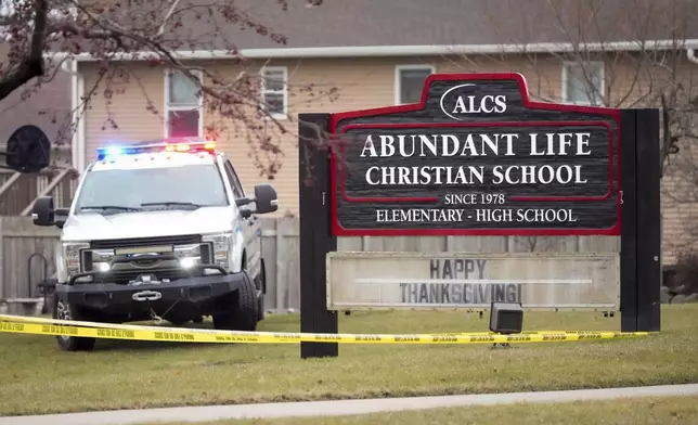 Emergency vehicles are parked outside the Abundant Life Christian School in Madison, Wis., following a shooting, Monday, Dec. 16, 2024. (AP Photo/Morry Gash)