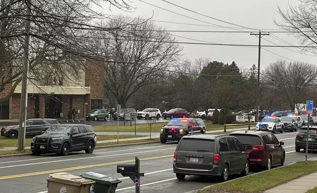 Emergency vehicles are parked outside the Abundant Life Christian School in Madison, Wis., where multiple injuries were reported following a shooting, Monday, Dec. 16, 2024. (AP Photo/Scott Bauer)