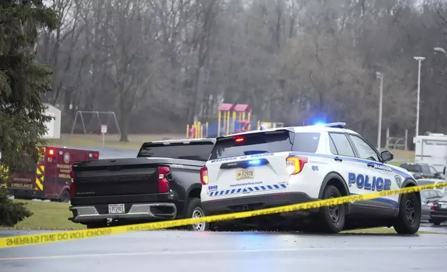 Emergency vehicles are parked outside the Abundant Life Christian School in Madison, Wis., where multiple injuries were reported following a shooting, Monday, Dec. 16, 2024. (AP Photo/Morry Gash)