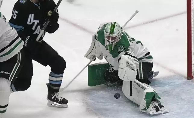 Dallas Stars goaltender Casey DeSmith, right, makes a save against Utah Hockey Club center Alexander Kerfoot (15) during the first period of an NHL hockey game Monday, Dec. 2, 2024, in Salt Lake City. (AP Photo/Rick Bowmer)