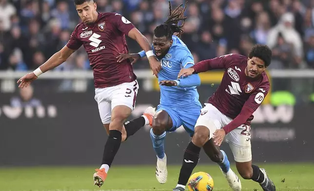 Torino's Adam Masina and Torino's Saul Coco battles for the ball with Napoli's Andre-Frank Zambo Anguissa during the Serie A soccer match between Torino FC and SSC Napoli the Stadio Olimpico Grande Torino in Turin, north west Italy, Sunday, Nov. 24, 2024. (Alberto Gandolfo/LaPresse via AP)