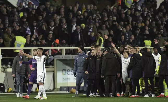 An ambulance enters the field as Fiorentina's Edoardo Bove, injured, is surrounded by players during the Serie A soccer match between Fiorentina and Inter at the Artemio Franchi Stadium in Florence, Italy, Sunday Dec. 1, 2024. The match was suspended and finally postponed as the injures appeared to be serious. (Massimo Paolone/LaPresse via AP)