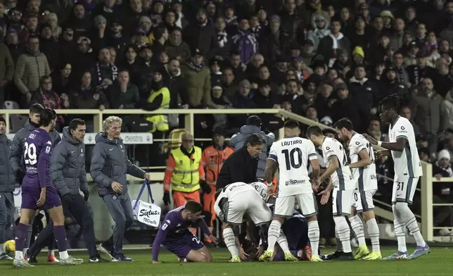 Fiorentina's Edoardo Bove, injured, is surrounded by players during the Serie A soccer match between Fiorentina and Inter at the Artemio Franchi Stadium in Florence, Italy, Sunday Dec. 1, 2024 (Massimo Paolone/LaPresse via AP)