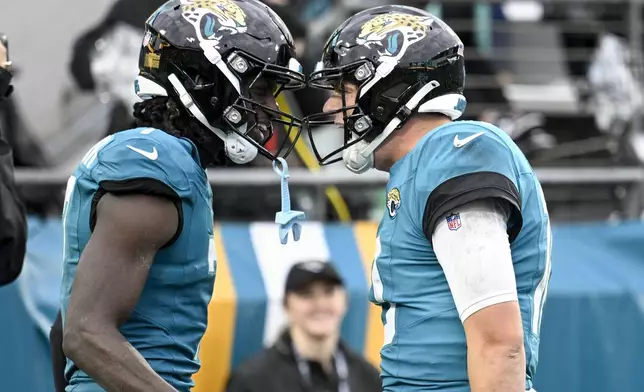 Jacksonville Jaguars wide receiver Brian Thomas Jr., left, and Jacksonville Jaguars quarterback Mac Jones, right, celebrate a touchdown during the second half of an NFL football game against the Tennessee Titans, Sunday, Dec. 29, 2024, in Jacksonville, Fla. (AP Photo/Phelan M. Ebenhack)