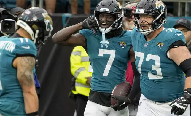 Jacksonville Jaguars wide receiver Brian Thomas Jr. (7) celebrates his touchdown with wide receiver Parker Washington (11) and offensive lineman Blake Hance (73) during the second half of an NFL football game against the Tennessee Titans, Sunday, Dec. 29, 2024, in Jacksonville, Fla. (AP Photo/John Raoux)