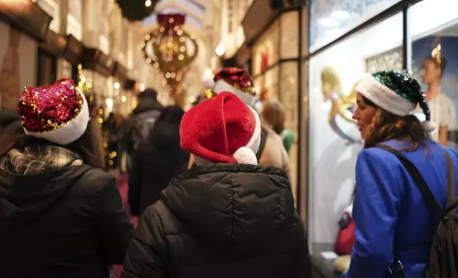 Christmas shoppers out wearing seasonal hats in central London, Friday, Dec. 13, 2024, Britain's economy unexpectedly shrank by 0.1 percent in October, The Office for National Statistics stated in figures released Friday. (AP Photo/Alberto Pezzali, Pool)