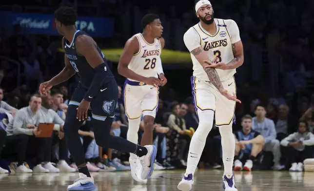 Los Angeles Lakers forward Anthony Davis (3) gestures after making a three-point basket as Memphis Grizzlies forward Jaren Jackson Jr. looks away during the first half of an NBA basketball game, Sunday, Dec. 15, 2024, in Los Angeles. (AP Photo/Jessie Alcheh)