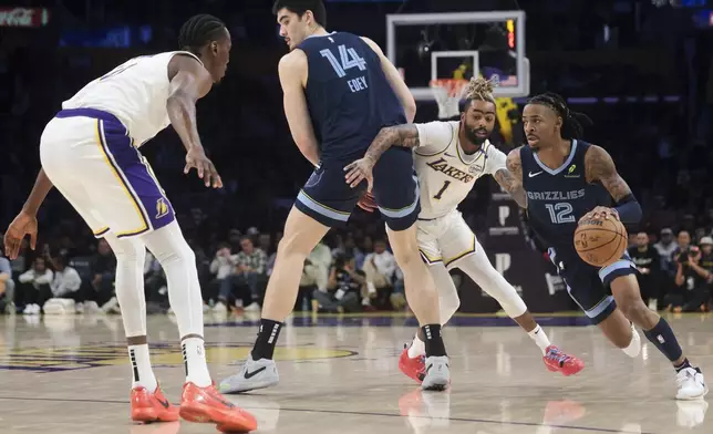 Memphis Grizzlies guard Ja Morant (12) drives against Los Angeles Lakers guard D'Angelo Russell (1) after a screen by center Zach Edey (14) as Los Angeles Lakers center Christian Koloko (10) watches during the first half of an NBA basketball game, Sunday, Dec. 15, 2024, in Los Angeles. (AP Photo/Jessie Alcheh)