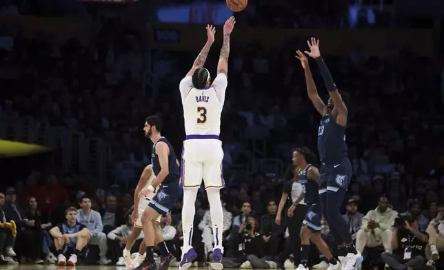 Los Angeles Lakers forward Anthony Davis (3) shoots a three-point basket against Memphis Grizzlies forward Jaren Jackson Jr. (13) during the first half of an NBA basketball game, Sunday, Dec. 15, 2024, in Los Angeles. (AP Photo/Jessie Alcheh)