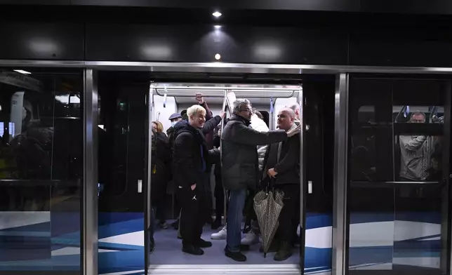 Commuters inside a metro wagon during the inauguration day of the Thessaloniki metro, in Thessaloniki, northern Greece, Saturday, Nov. 30, 2024. (AP Photo/Giannis Papanikos)