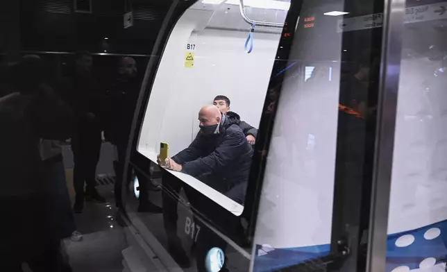 A passenger takes photographs from inside a metro wagon during the inauguration day of the Thessaloniki metro, in Thessaloniki, northern Greece, Saturday, Nov. 30, 2024. (AP Photo/Giannis Papanikos)