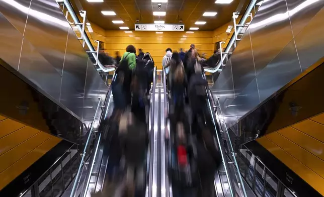 Commuters use escalators at a metro station during the inauguration day of the Thessaloniki metro, in Thessaloniki, northern Greece, Saturday, Nov. 30, 2024. (AP Photo/Giannis Papanikos)