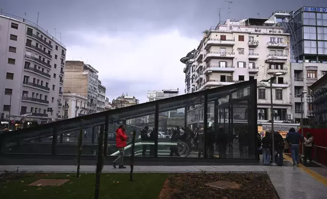 Commuters walk around a metro station during the inauguration day of the Thessaloniki metro, in Thessaloniki, northern Greece, Saturday, Nov. 30, 2024. (AP Photo/Giannis Papanikos)