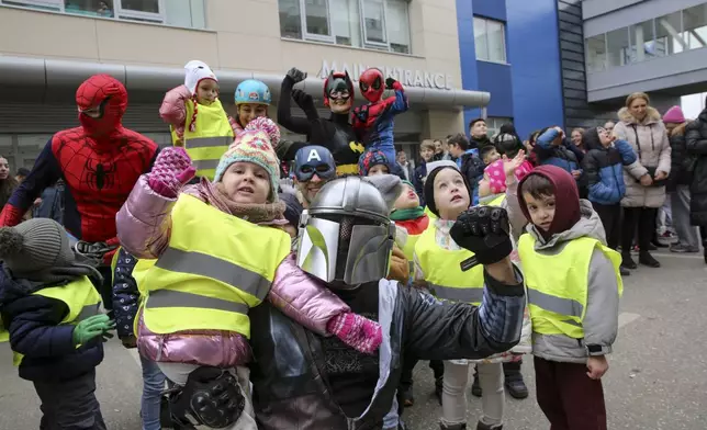 Kosovo alpinists disguised as super-heroes of modern times deliver New Year's gifts to kindergarden children and patients in Pristina hospital on Friday, Dec. 13, 2024. (AP Photo/Visar Kryeziu)