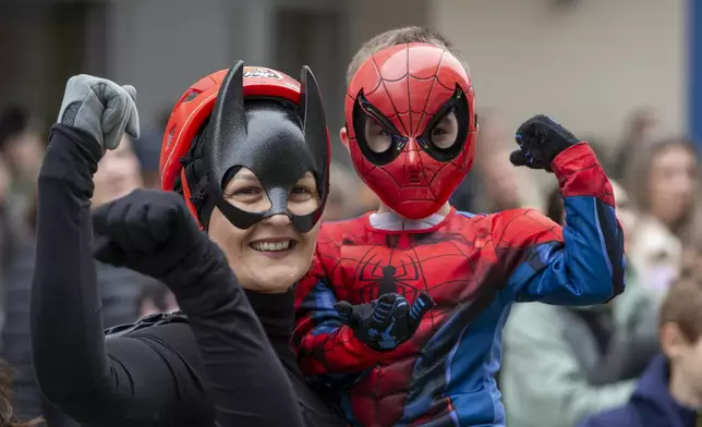 A child dressed as a superhero poses with a Kosovo alpinist disguised as super-heroes of modern times delivering New Year's gifts to children patients in Pristina hospital on Friday, Dec. 13, 20124. (AP Photo/Visar Kryeziu)