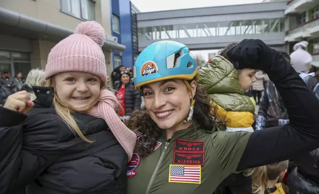 A child dressed as a superhero poses with a Kosovo alpinist disguised as super-heroes of modern times delivering New Year's gifts to children patients in Pristina hospital on Friday, Dec. 13, 20124. (AP Photo/Visar Kryeziu)