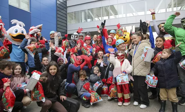 Children dressed as superheroes watch Kosovo alpinists disguised as super-heroes of modern times delivering New Year's gifts to children patients in Pristina hospital on Friday, Dec. 13, 20124. (AP Photo/Visar Kryeziu)