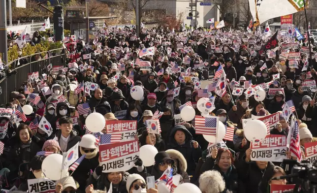 Supporters of impeached South Korean President Yoon Suk Yeol stage a rally near the presidential residence in Seoul, South Korea, Tuesday, Dec. 31, 2024. The letters read "Oppose Impeachment," and "Arrest Lee Jae-myung." (AP Photo/Lee Jin-man)