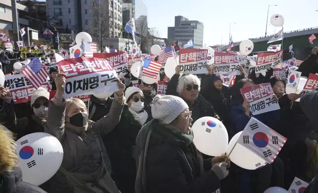 Supporters of impeached South Korean President Yoon Suk Yeol stage a rally near the presidential residence in Seoul, South Korea, Tuesday, Dec. 31, 2024. The letters read "Oppose Impeachment," and "Arrest Lee Jae-myung." (AP Photo/Lee Jin-man)