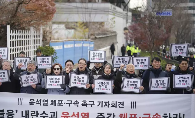 FILE - Members of civic groups shout slogans during a news conference demanding the arrest of President Yoon Suk Yeol near the presidential residence in Seoul, South Korea, on Dec. 17, 2024. The letters read "Immediately arrest Yoon Suk Yeol." (AP Photo/Lee Jin-man, File)