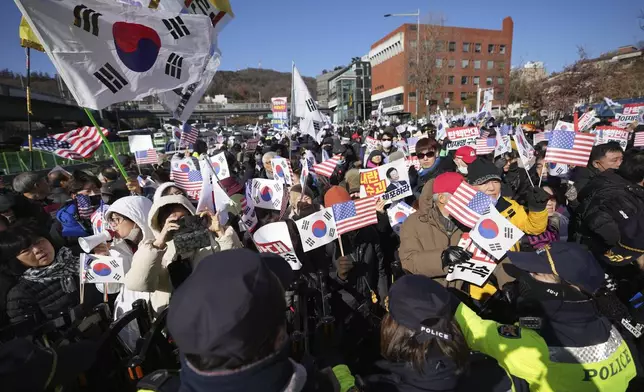 Supporters of impeached South Korean President Yoon Suk Yeol stage a rally after hearing a news that a court issued warrants to detain Yoon, near the presidential residence in Seoul, South Korea, Tuesday, Dec. 31, 2024. The letters read "Oppose Impeachment." (AP Photo/Lee Jin-man)