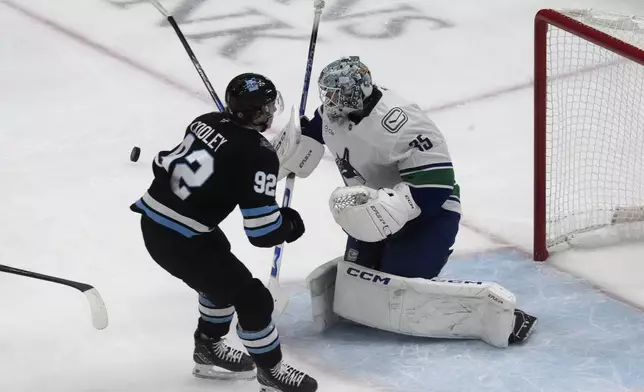 Vancouver Canucks goaltender Thatcher Demko (35) makes a save against Utah Hockey Club center Logan Cooley (92) during the first period of an NHL hockey game Wednesday, Dec. 18, 2024, in Salt Lake City. (AP Photo/Rick Bowmer)