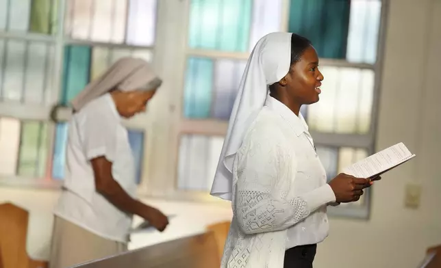 Sister Seyram Mary Adzokpa, right, of the Sisters of the Holy Family, sings during morning Mass at the motherhouse, in New Orleans, Wednesday, June 26, 2024. (AP Photo/Jessie Wardarski)