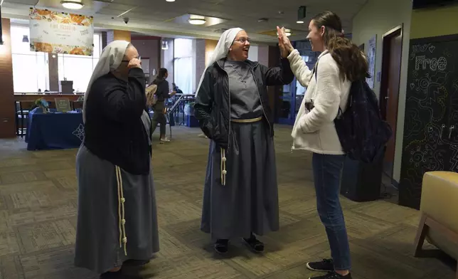 Sister Catherine Lynn Forsythe, left, and Sister Joan Paule Portenlanger of the Franciscan Sisters, T.O.R. of Penance of the Sorrowful Mother, talk with students on campus at Franciscan University, in Steubenville, Ohio, Thursday, Nov. 7, 2024. (AP Photo/Jessie Wardarski)