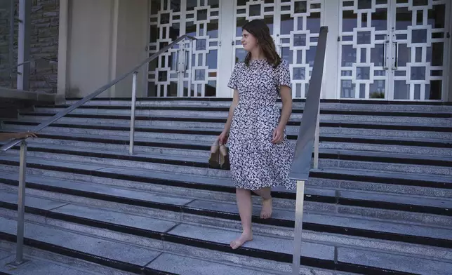 Zoey Stapleton carries her shoes while leaving morning Mass at her home parish, St. Joan of Arc Catholic Church in Hershey, Pa., Wednesday, July 3, 2024. (AP Photo/Jessie Wardarski)