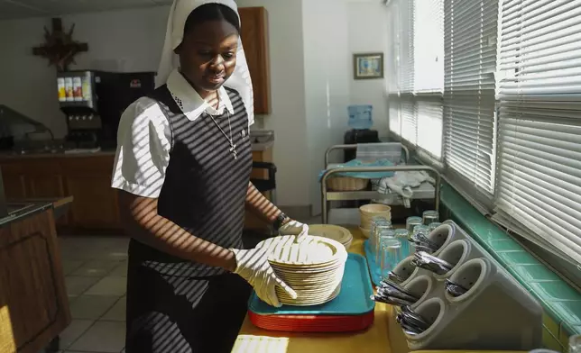 Sister Seyram Mary Adzokpa puts dishes away after breakfast at the Sisters of the Holy Family motherhouse in New Orleans, Tuesday, June 25, 2024. (AP Photo/Jessie Wardarski)