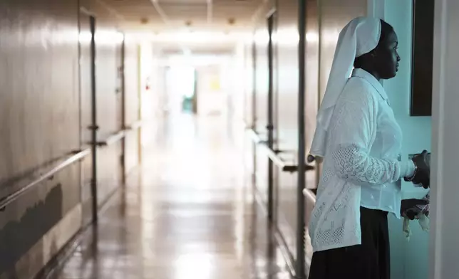 Sister Seyram Mary Adzokpa makes her morning rounds caring for the elderly sisters at the motherhouse of the Sisters of the Holy Family in New Orleans, Wednesday, June 26, 2024. (AP Photo/Jessie Wardarski)