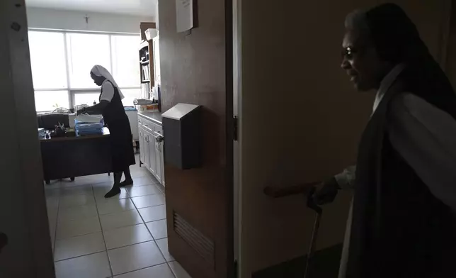 Sister Seyram Mary Adzokpa, left, works as a nurse as part of her ministry at the Sisters of the Holy Family in New Orleans, Tuesday, June 25, 2024. (AP Photo/Jessie Wardarski)